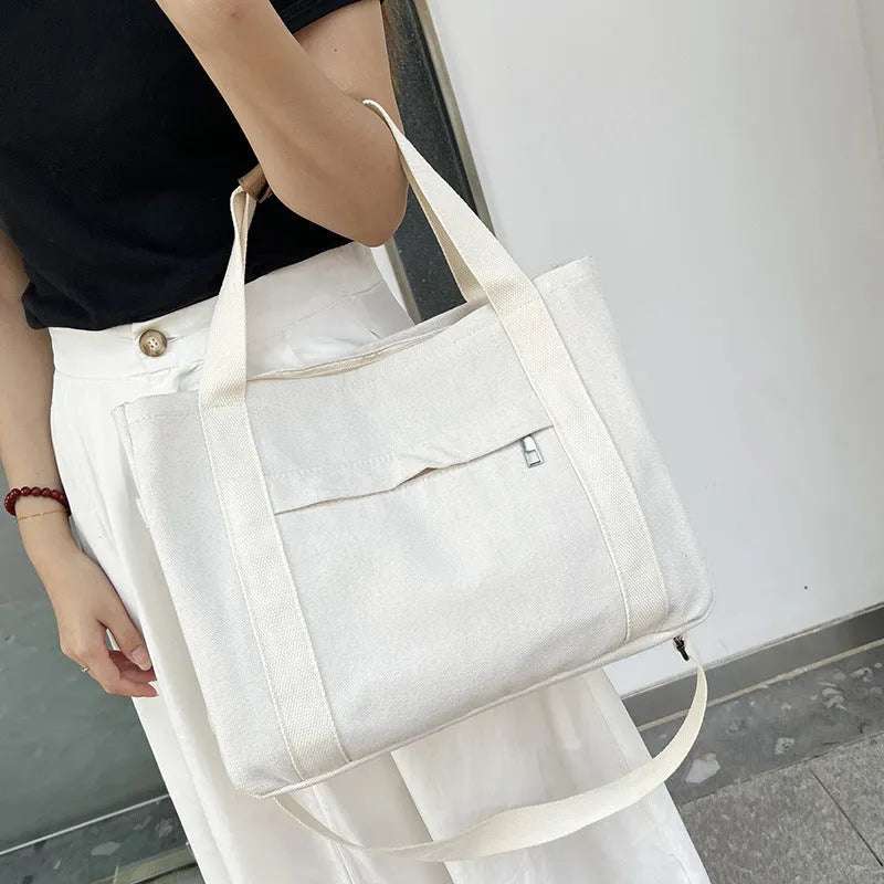 Canvas tote bag showing multiple internal compartments and both sides zipper openings in horizontal square shape