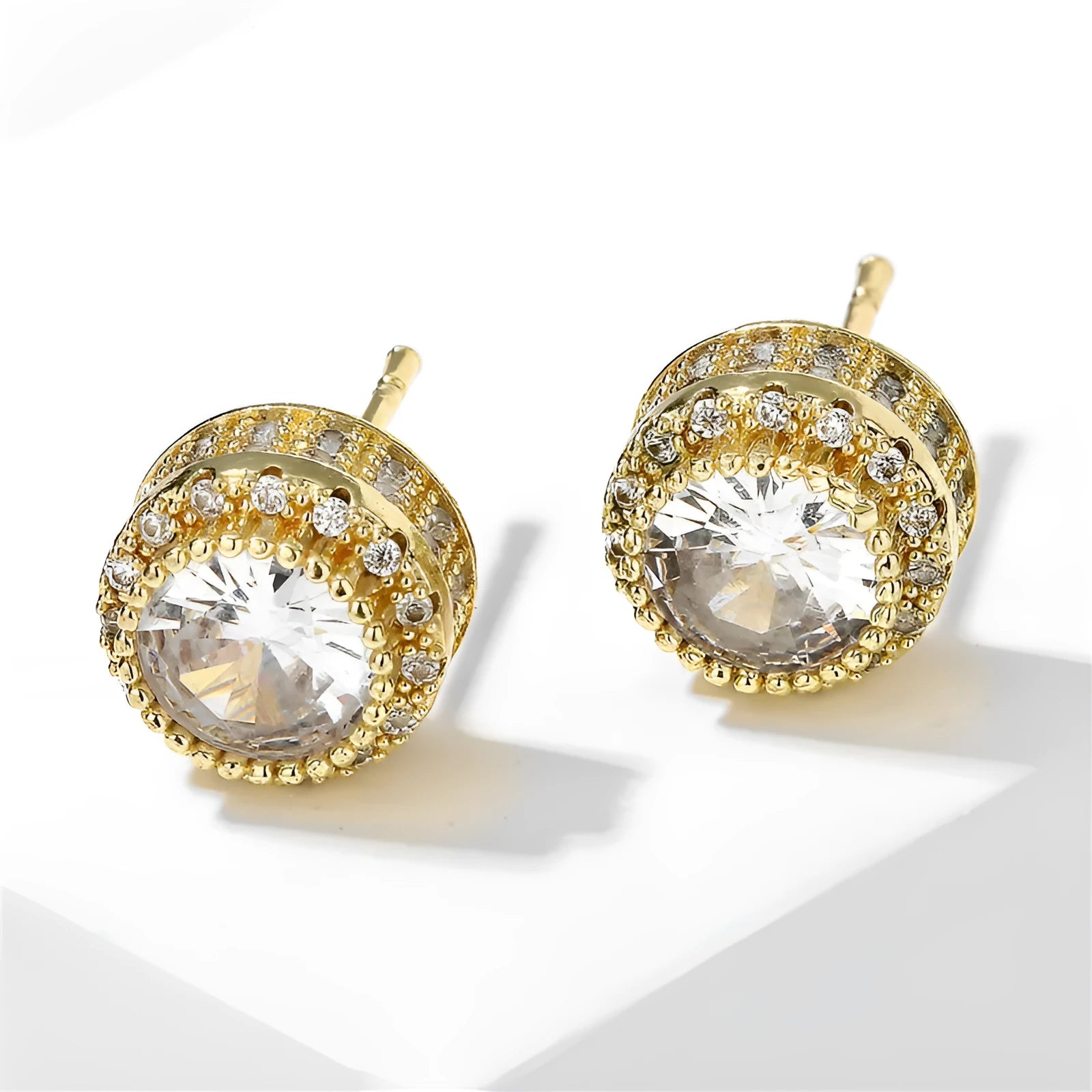 Round copper stud earrings with inlaid zircon in gold tone on white background