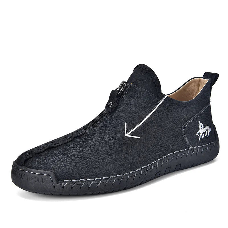 Men's black front-zip casual boots with round toe and low heel, showing the side zipper and rubber sole.