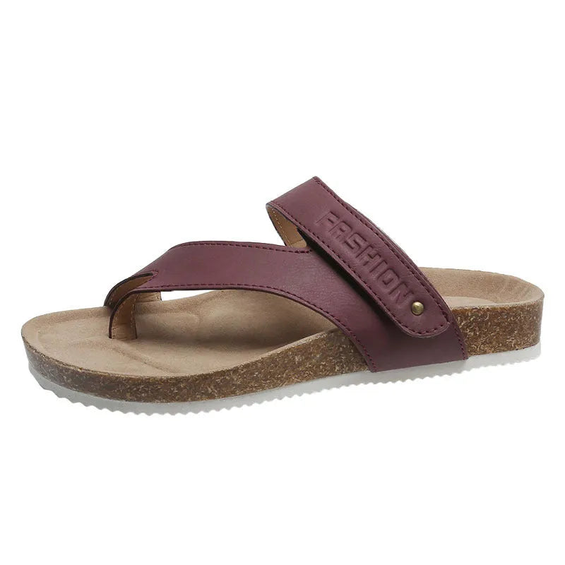 Thick-soled blue flip-flops with flat toe ring design on beach background