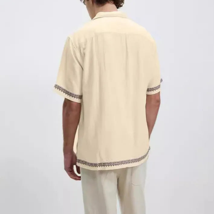 Men's apricot-coloured short-sleeve shirt with vintage floral print and lapel collar on a hanger.