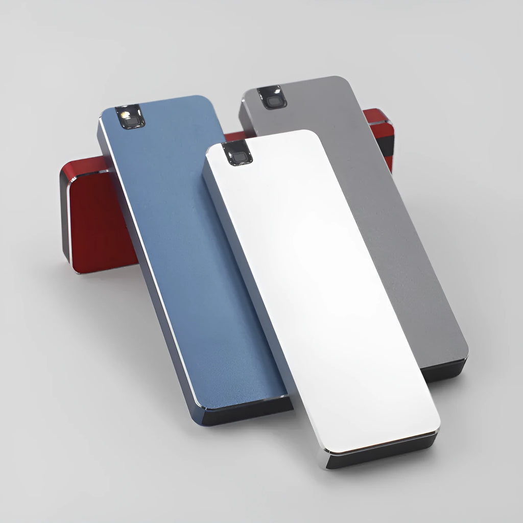 White metal portable external SSD hard drive with USB cable on a grey background