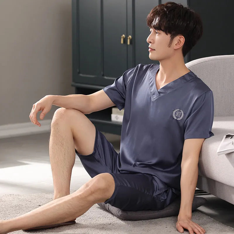 Man wearing a light grey ice silk short-sleeve pajama shirt and matching loose shorts.