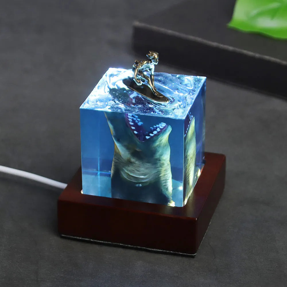 Epoxy resin shark surfer night light ornament with crystal glue details on blue background
