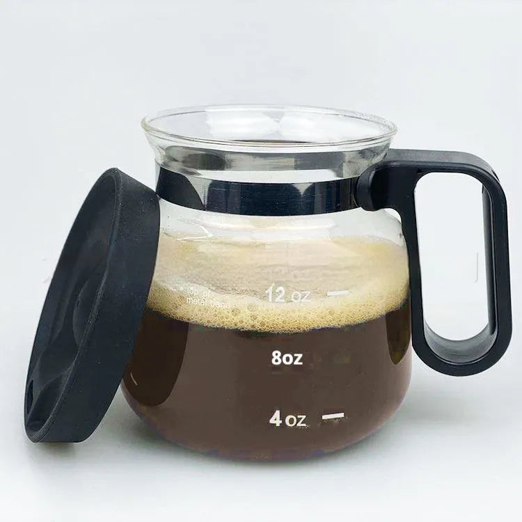 Transparent borosilicate glass coffee maker with black silicone cover on a kitchen counter