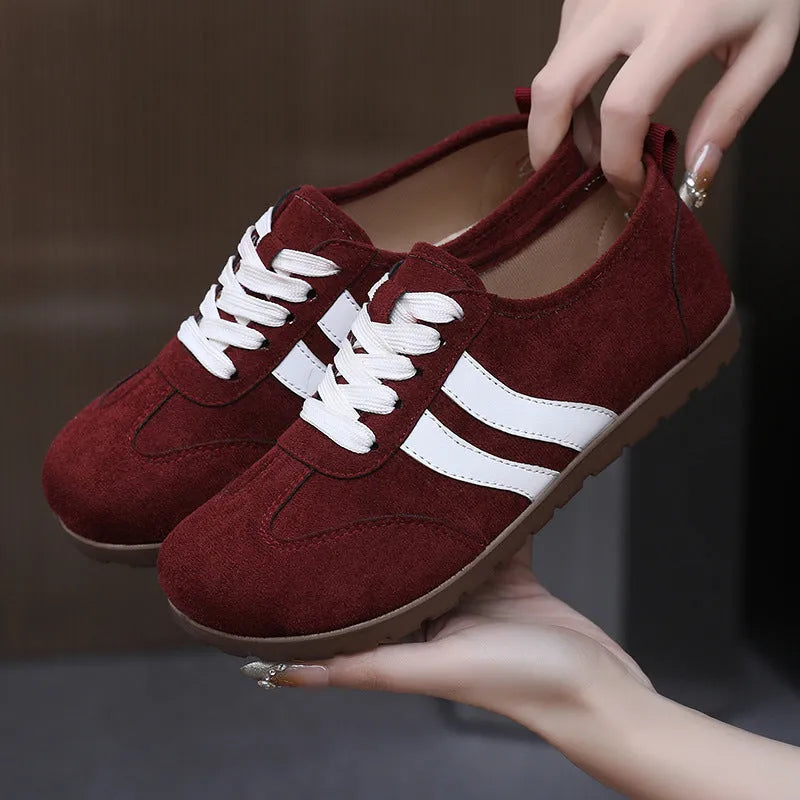 Women's vintage-style canvas sneakers with round toe and flat rubber sole in dark red.