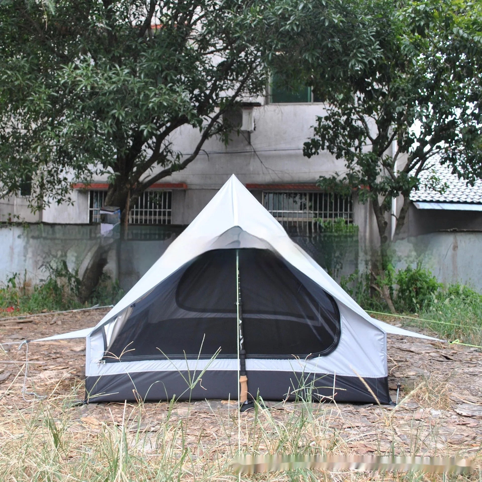 Brown A-line pole-free portable tent with hiking cane support showing interior space for 2-3 people