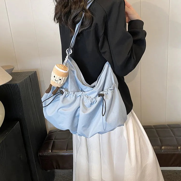 Green ultra-light pleated crossbody student bag showing folding design and split outer pocket