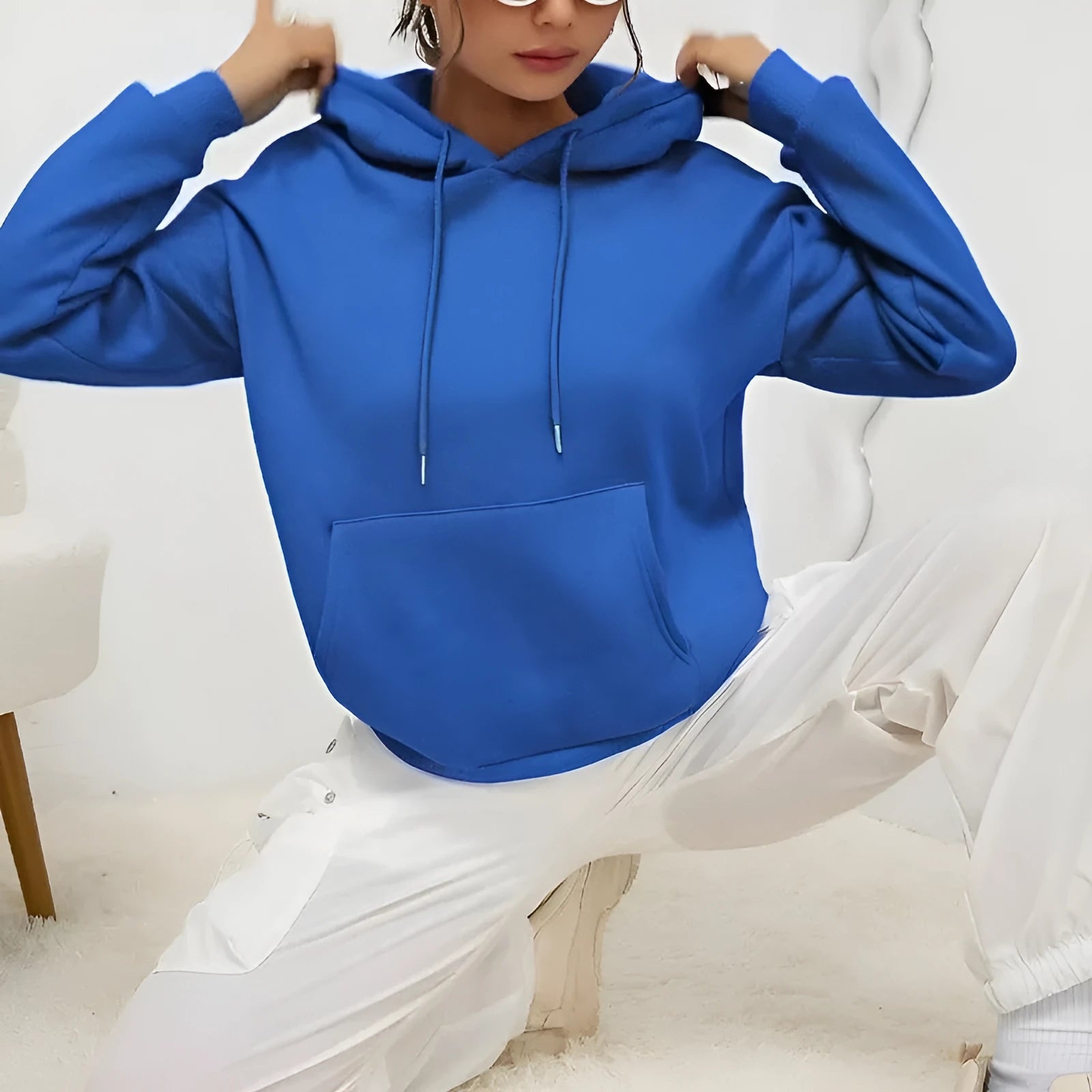Women's loose fit grey sweatshirt with front drawstring detail and long sleeves on a hanger