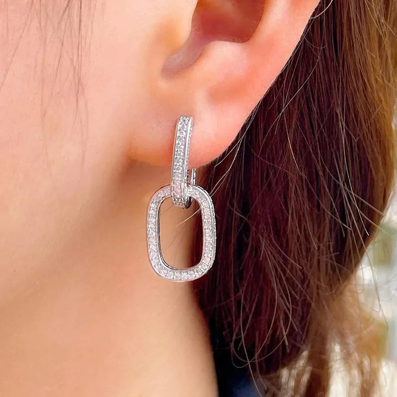 Pair of copper geometric U-shaped earrings with inlaid zircon in white gold colour