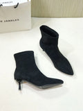 Black pointed toe ankle boots with stiletto heels and mid-calf length