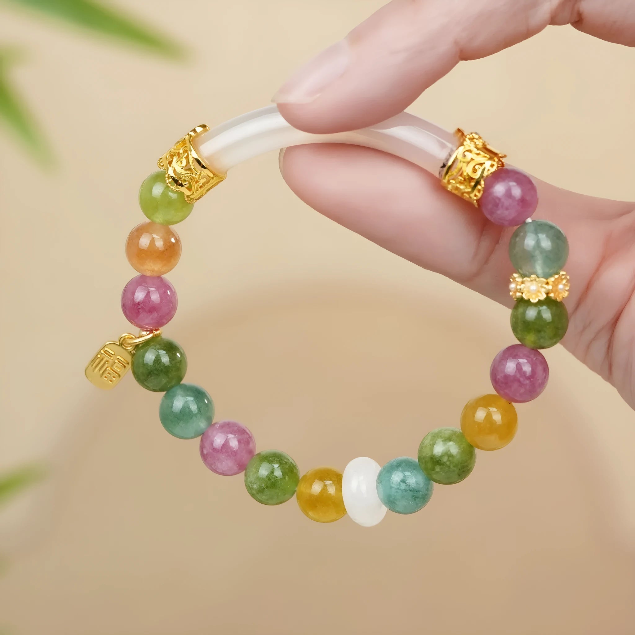 Rainbow coloured tourmaline half bracelet for women on a wrist, showing electroplated finish.