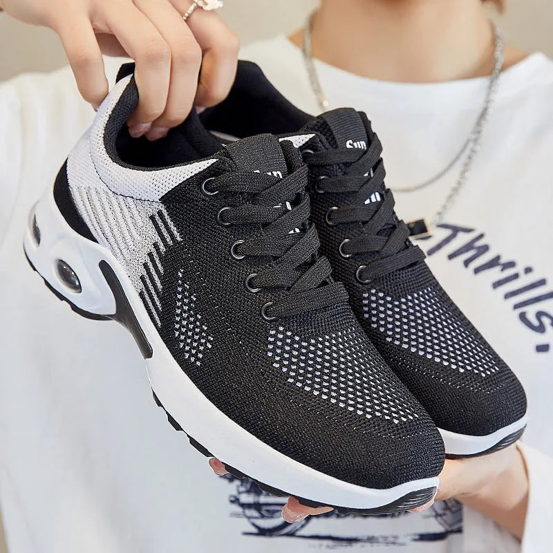 Women's Flyknit casual running shoes in pink with lace-up front and flat PVC sole.