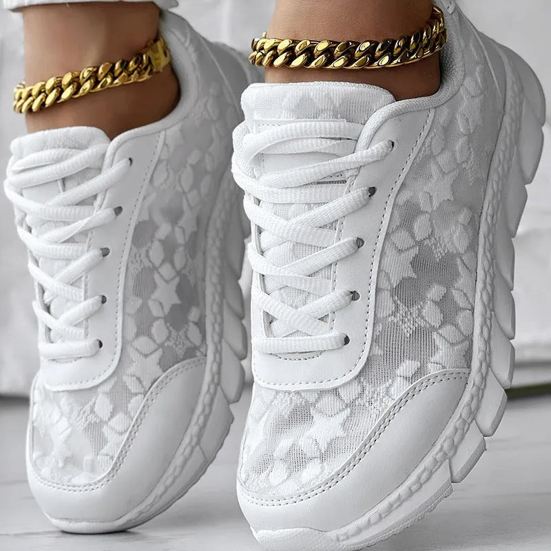 Women's white canvas running shoe with flat heel and soft sole on a light background.