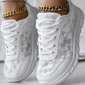 Women's white canvas running shoe with flat heel and soft sole on a light background.