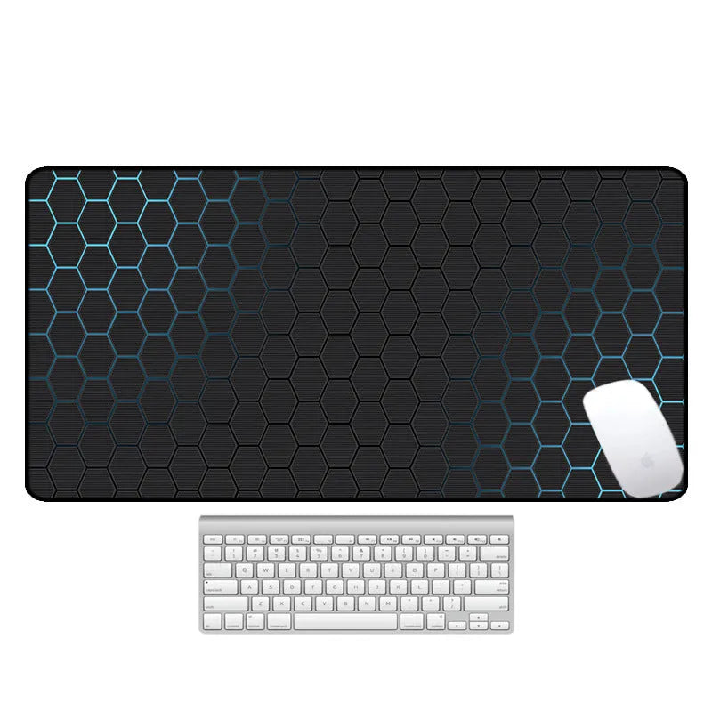 Large black rubber desk mouse pad with a printed geometric pattern, shown on a wooden desk.