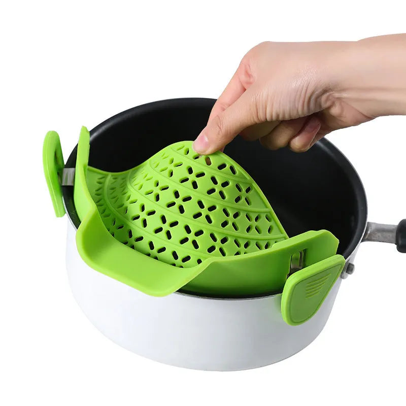 Silicone pot side drain stopper in black on a stainless steel pot edge, 11.3x22.5x5.9cm kitchen gadget
