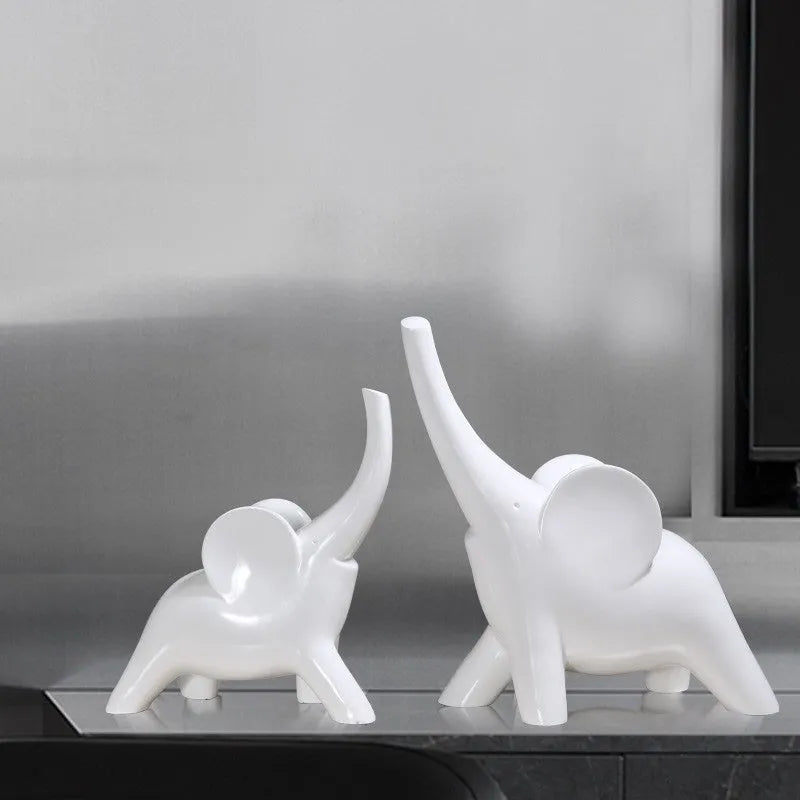 Minimalist rose gold and white resin elephant ornaments on a shelf, showing large and small sizes.