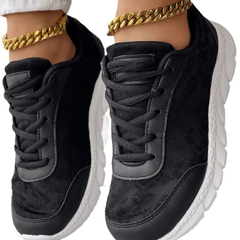 Women's white canvas running shoe with flat heel and soft sole on a light background.