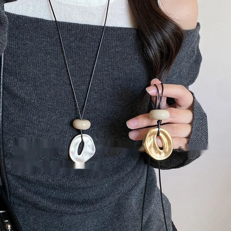 Geometric bow pendant necklace in gold alloy with artificial crystal accents on ladies long chain