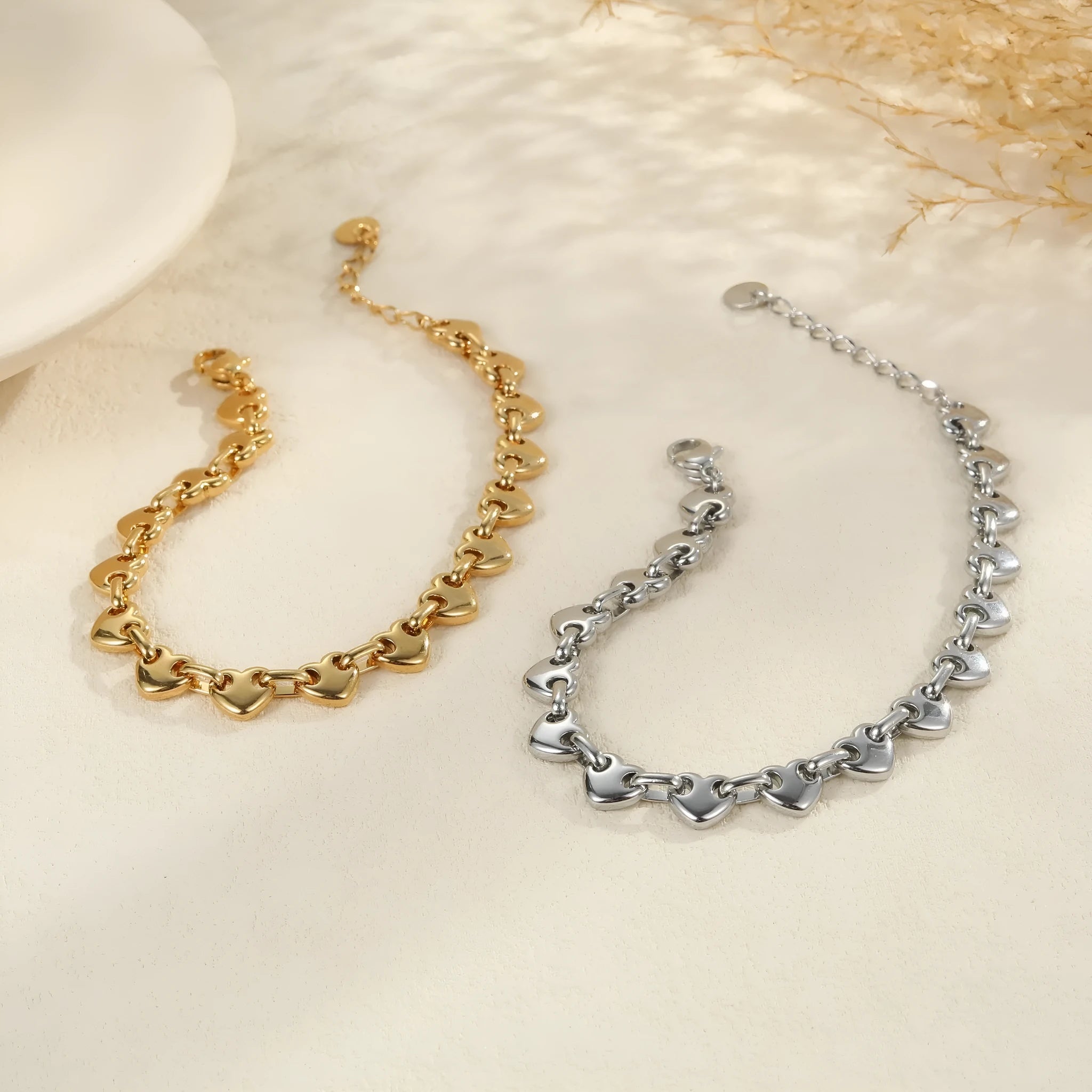 Hollowed-out heart geometry bracelet in stainless steel with gold electroplated finish on a wrist.