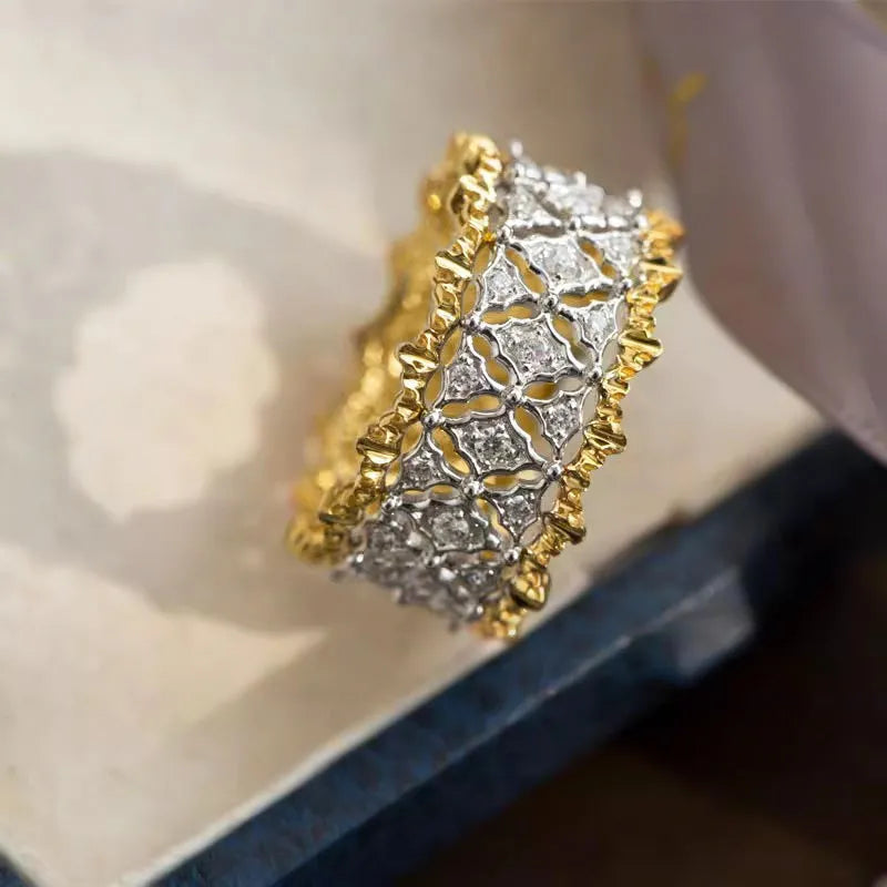 Geometric two-tone gold plated ring with round zircon centre on a plain background.