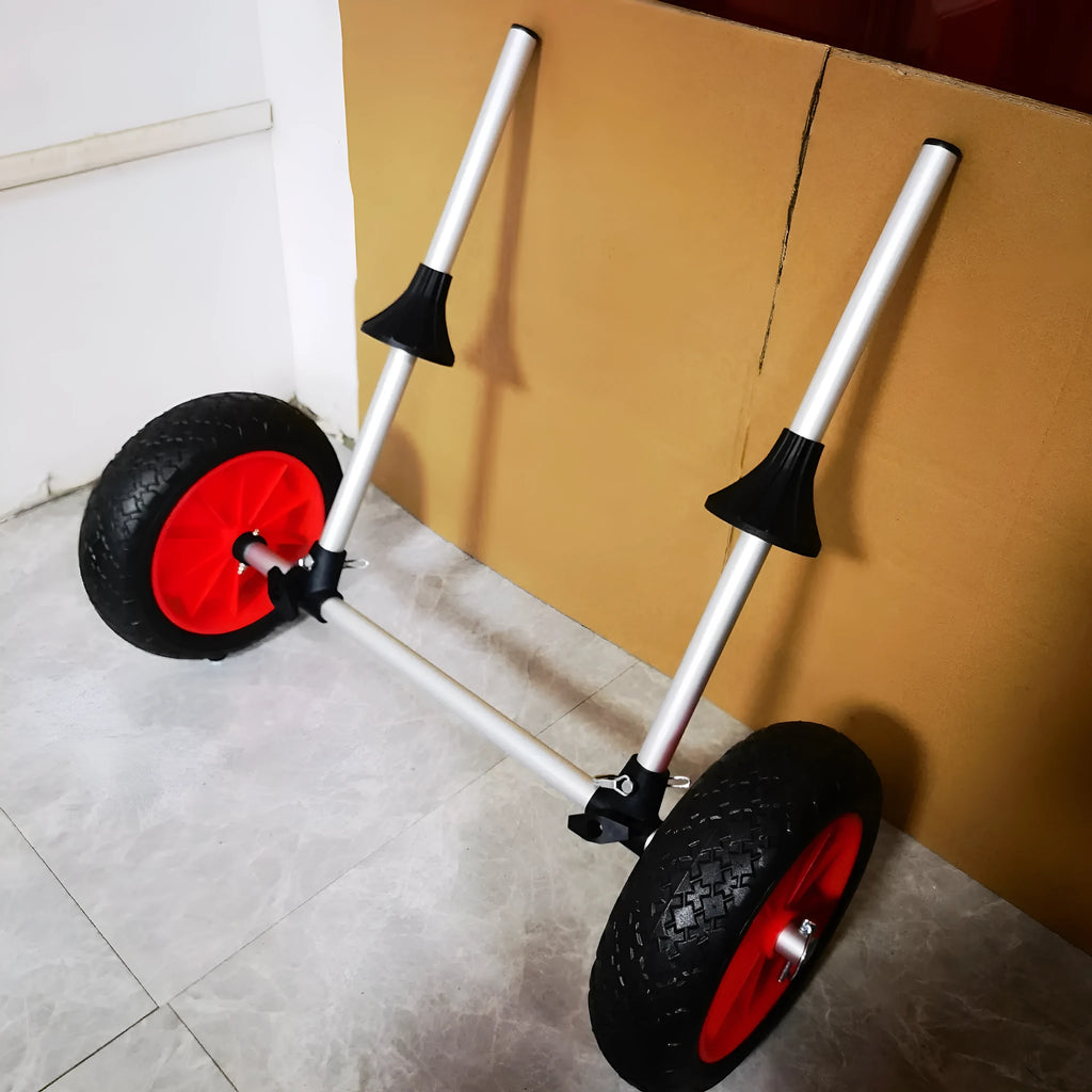 Foldable aluminium kayak cart with upright pole platform and wheels on a beach.