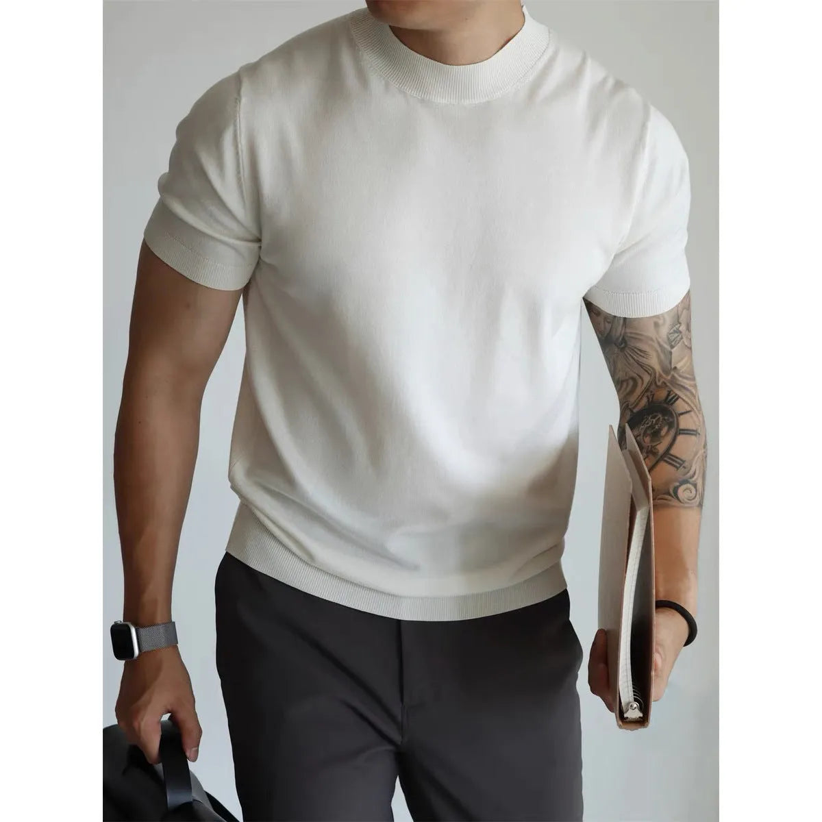 Man wearing a slim-fit solid colour polyester t-shirt, showcasing its lightweight knitwear construction.