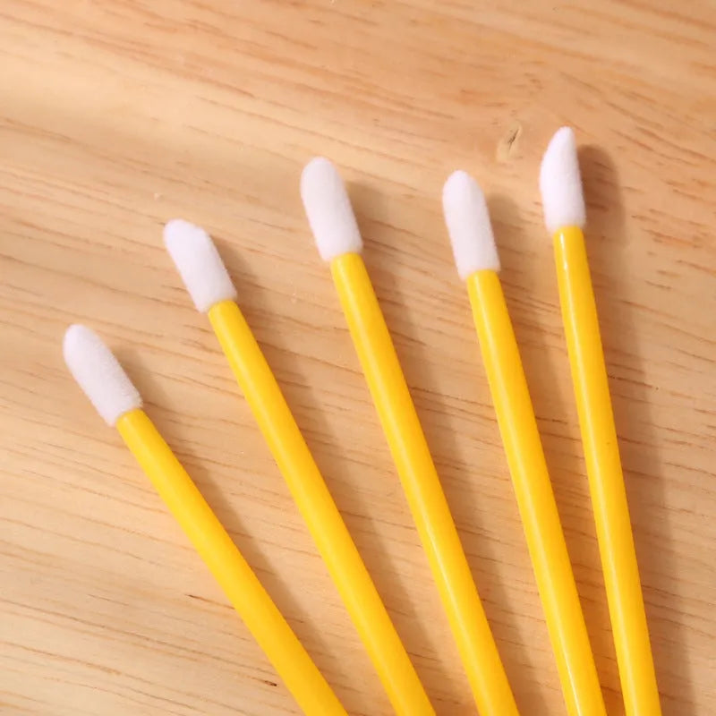 Pack of disposable lip brush wands with flocked brush tips and coloured handles.