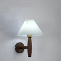 American retro style adjustable wall lamp in walnut wood with a fabric shade, mounted beside a bed.