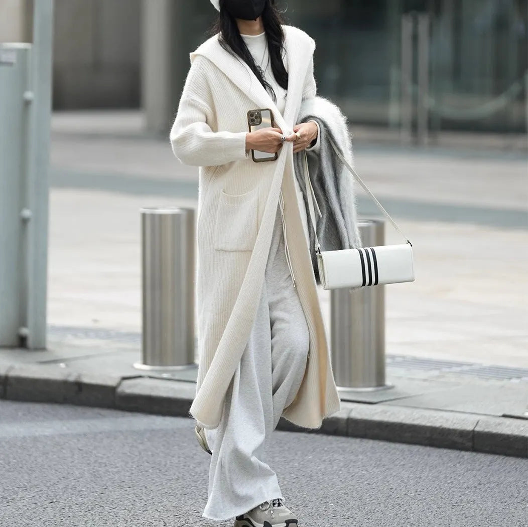 Long grey knitted hooded trench coat with a loose, cardigan-style fit and long sleeves.