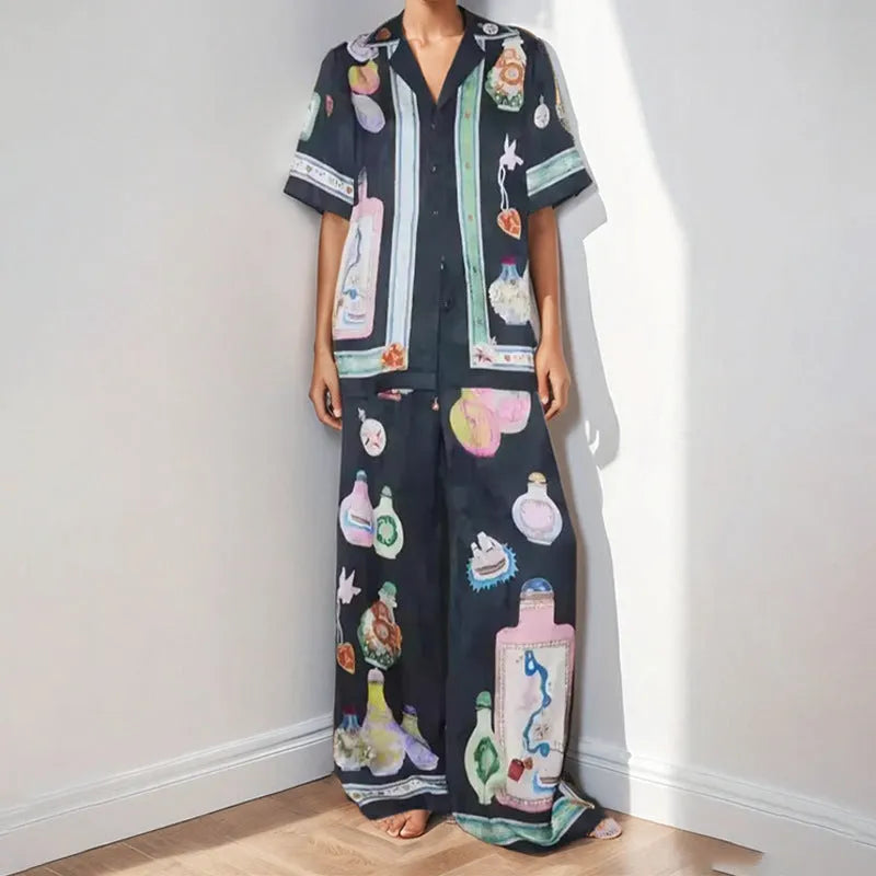 Black women's pyjama set with cartoon print pattern showing matching trousers and top