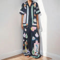 Black women's pyjama set with cartoon print pattern showing matching trousers and top