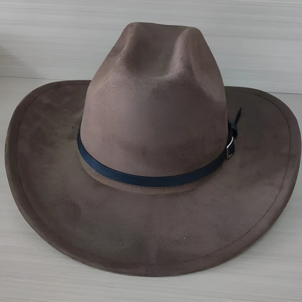 Brown leather velvet curved edge Western cowboy hat with a conical crown on a table.