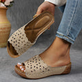 Women's black beach slippers with flower cutout design on the PVC upper and a rubber wedge sole.