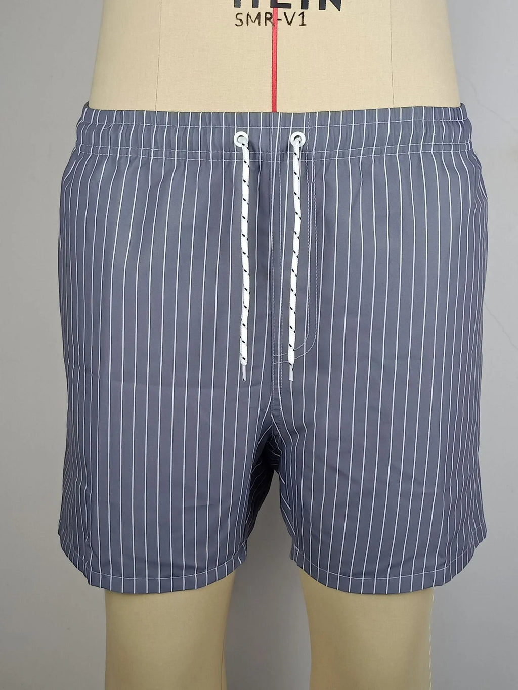 Polyester fibre beach shorts with digital printed striped triangle lining in straight leg style