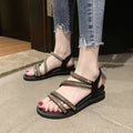 Women's silver flat sandals with rhinestone decoration and elastic band, shown on a white background.