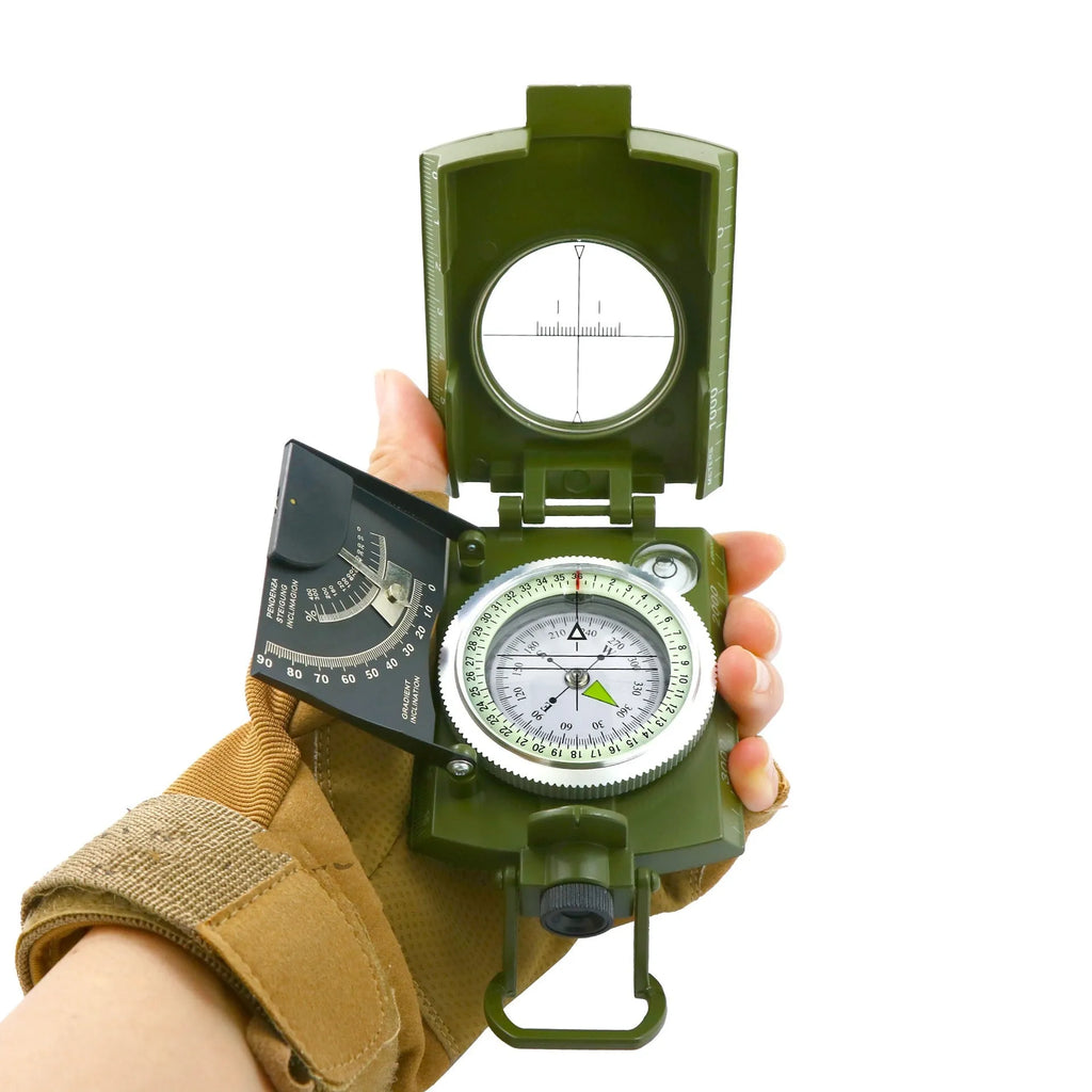 K4074 silver and black metal professional compass with hanging rope on a green background.