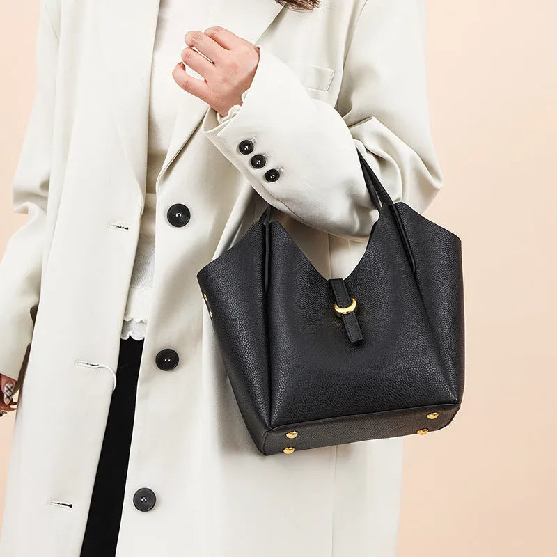 Genuine leather women's retro bucket handbag in beige with top handles and visible stitching.