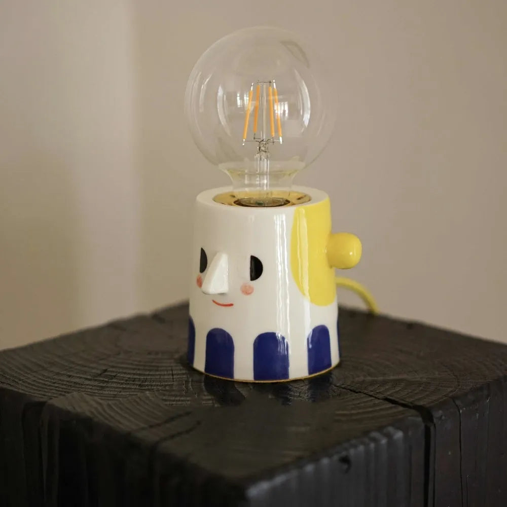 Handmade ceramic table lamp with ball headlight design on wooden surface