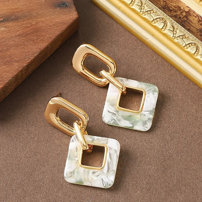 Pair of hollow geometric square earrings with chamfered pattern in silver or black electroplated finish.