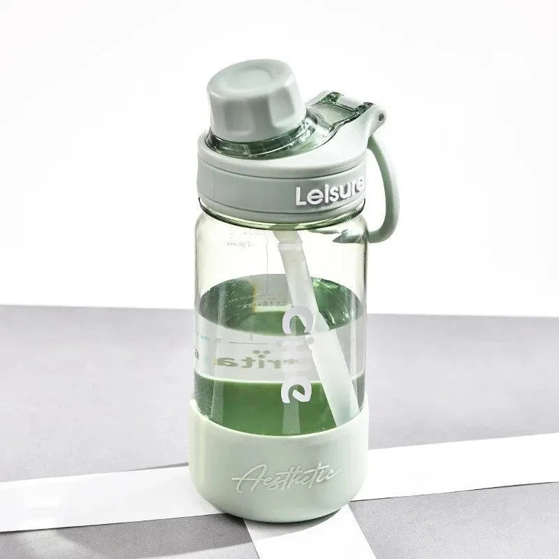 Grey plastic straw cup showing integrated straw and cylindrical shape on a table.