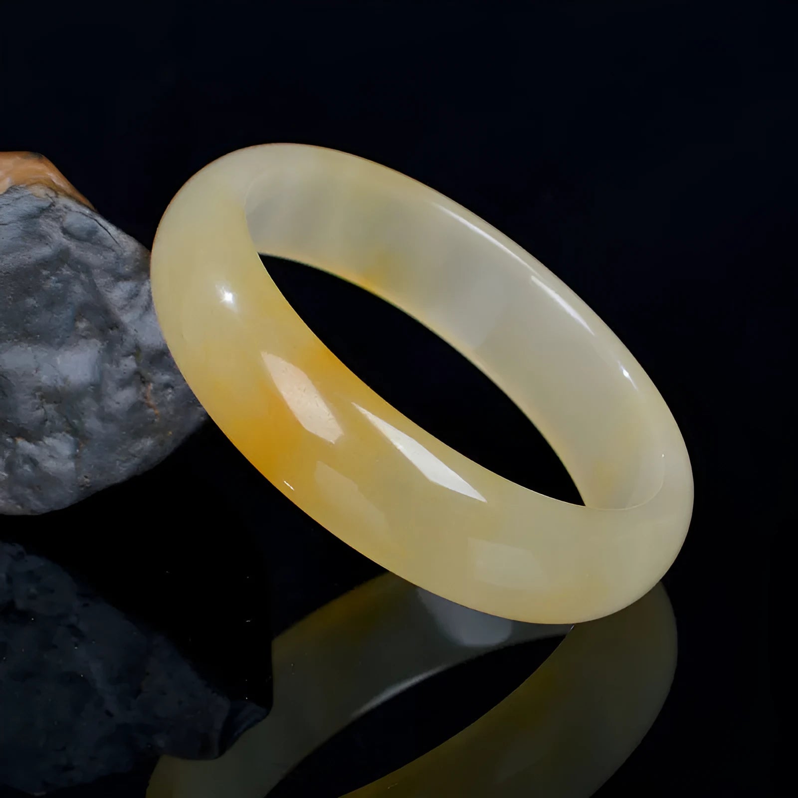 Natural light green jade bracelet in Chinese style, shown on a wrist, with a polished surface.