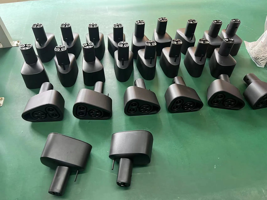 Black Tesla charging plug conversion adapter showing connection pins and dustproof housing