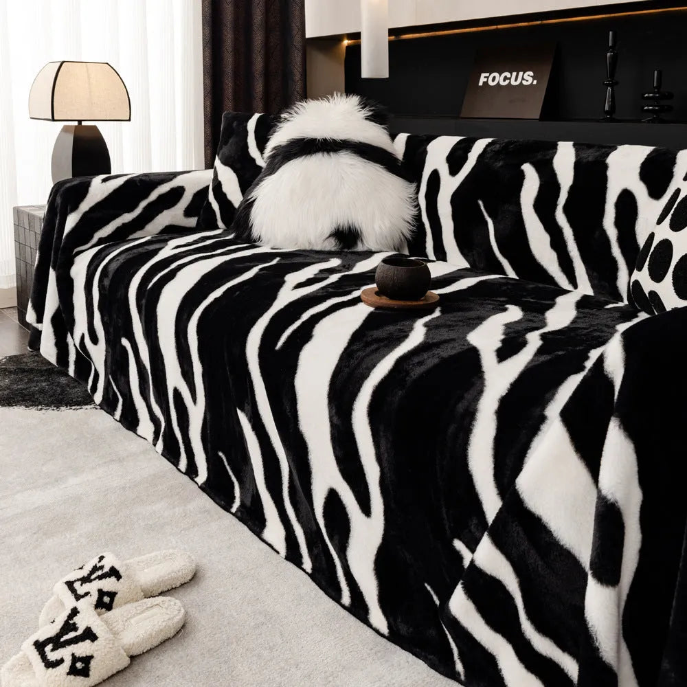Zebra pattern flannel sofa slipcover in caramel colour, shown draped over a sofa with matching square pillow.