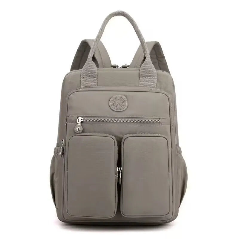 Waterproof women's large capacity nylon travel backpack in multiple colours showing internal laptop compartment and pockets.