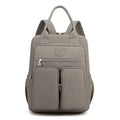Waterproof women's large capacity nylon travel backpack in multiple colours showing internal laptop compartment and pockets.