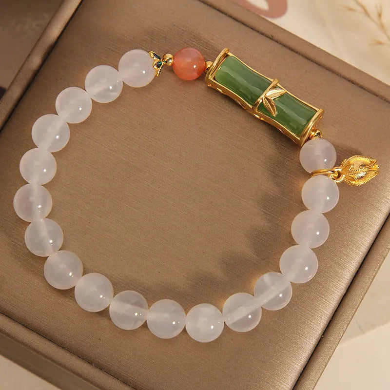 Women's white agate jade bracelet with bamboo joint beads on a wrist.