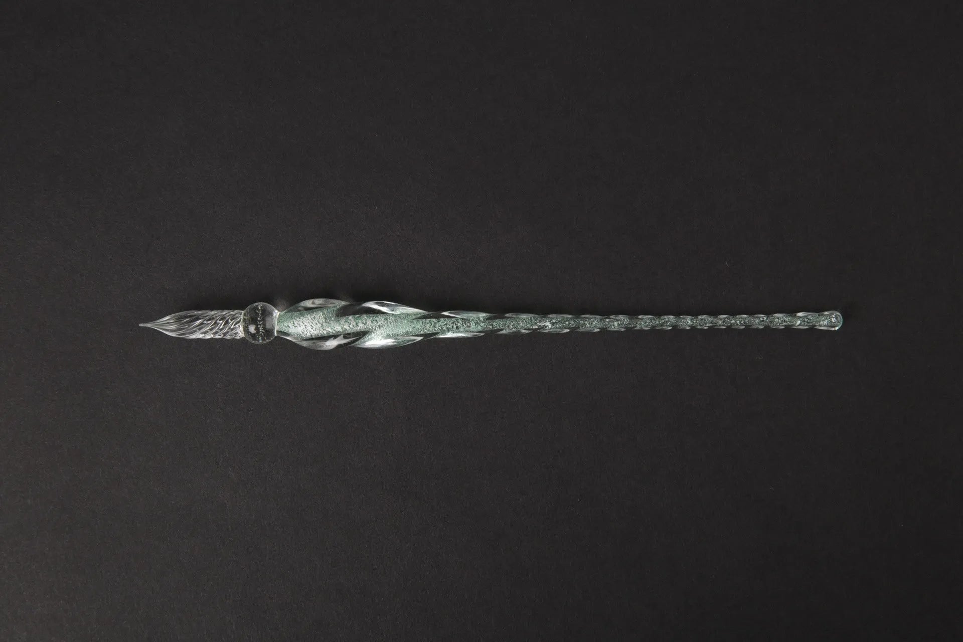 Hand-blown glass crystal pen with coloured ink in a transparent barrel on a gift box.