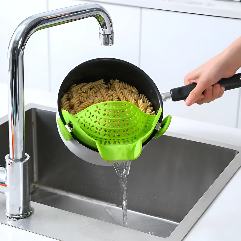 Silicone pot side drain stopper in black on a stainless steel pot edge, 11.3x22.5x5.9cm kitchen gadget